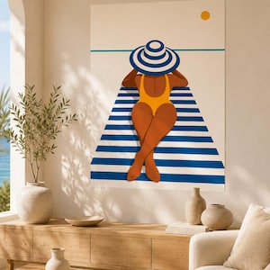 Könnte beinhalten: Ein Wandkunstdruck mit einer stilisierten Illustration einer Person in einem gelben Badeanzug und einem blau-weiß gestreiften Sonnenhut, die auf einem blau-weiß gestreiften Strandtuch unter einer kleinen gelben Sonne auf cremefarbenem Grund liegt.