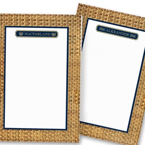 May include: Two blank stationery note cards with a woven wicker pattern border. The top of each card has a navy blue border with gold lettering. The left card says "MacFarland" and the right card says "Alexander".