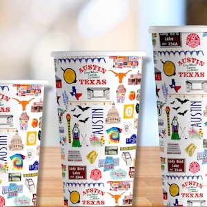 May include: Three white paper cups with a colorful design featuring the text "Austin, Live Music Capital of the World, Texas". The design includes various illustrations of landmarks, symbols, and text related to Austin, Texas.