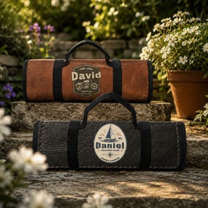 May include: Two rectangular carrying cases with black handles. The top case is brown with a graphic featuring a motorcycle and the name David. The bottom case is black with a graphic featuring a sailboat, the name Daniel, and Sailing Club text.