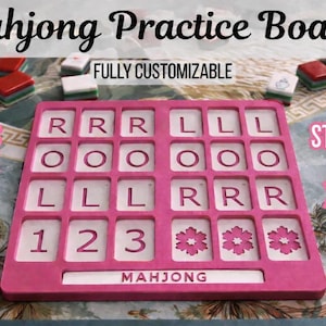 May include: A pink Mahjong practice board with a grid of rectangular slots containing white tiles printed with letters, numbers, and flower icons. The board features the text Mahjong, Fully Customizable, Flowers, Birdbam, Dragon, Bam, Joker, Lotus, Standard or XL Tile Sizes.