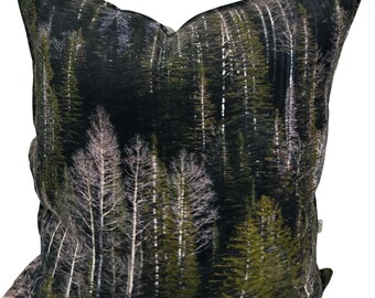 May include: Square throw pillow featuring a forest scene with tall, green evergreen trees and white-trunked trees. The pillow has a dark background, creating a sense of depth and a natural aesthetic. The pillow is a decorative home accent.