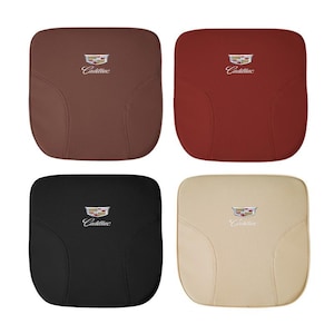 Puede incluir: Cuatro cojines para asientos de coche en diferentes colores: marrón, rojo, negro y beige. Cada cojín tiene el logotipo de Cadillac bordado. Los cojines son cuadrados y parecen estar hechos de cuero o un material similar.