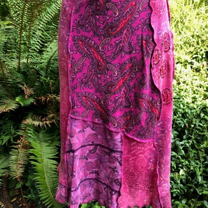May include: A pink and purple patchwork skirt with a paisley print and a scalloped hem.