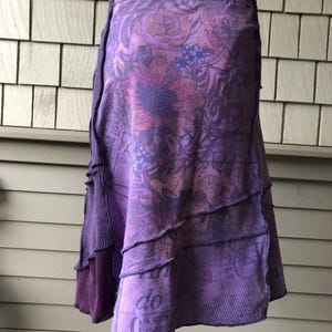 Peut inclure: Une jupe violette à imprimé floral et à plusieurs couches. La jupe est faite d'un tissu doux et confortable et a une coupe ample.