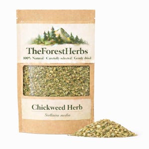 May include: A brown paper pouch containing dried Chickweed Herb, labeled with TheForestHerbs logo, a mountain graphic, and the text 100% Natural, Carefully selected, Gently dried, and Stellaria media, with a small pile of the herb beside it.