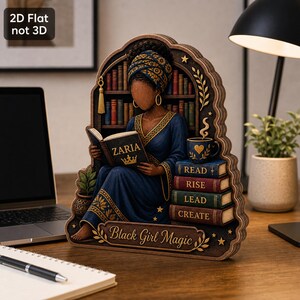 May include: A 2D flat wooden decorative cutout featuring a person wearing a blue robe and headwrap, reading a book labeled ZARIA. Beside them is a stack of books labeled READ, RISE, LEAD, CREATE, and a mug. The base text reads Black Girl Magic.