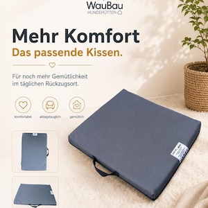 Könnte beinhalten: Ein quadratisches, dunkelgraues Haustierkissen mit einem schwarzen Tragegriff an einer Seite und einem kleinen weißen Etikett. Der Text auf dem Bild lautet WauBau HUNDEHÜTTEN, Mehr Komfort, Das passende Kissen, Für noch mehr Gemütlichkeit im täglichen Rückzugsort, komfortabel, alltagstauglich, gemütlich.