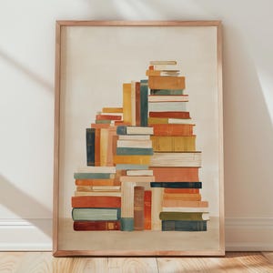 May include: A framed art print featuring a stack of colorful books. The books are in various sizes and colors, including orange, blue, yellow, and green. The artwork is set against a neutral background and framed in a light wood.