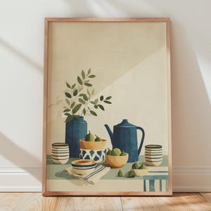 Op de afbeelding: Een ingelijste wandkunstprint met een stillevenillustratie van een blauwe theepot, een hoge blauwe vaas met groene bladeren en verschillende kleine kommen met groene vijgen, allemaal gerangschikt op een tafel met een gestreept kleed.