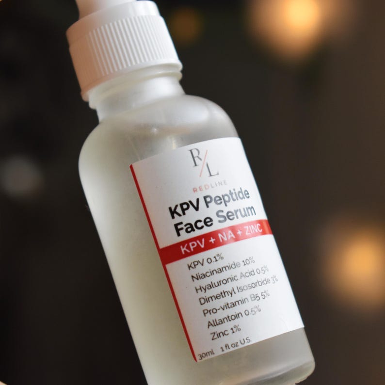 May include: A frosted glass dropper bottle containing KPV Peptide Face Serum. The white label features the text R/L REDLINE, KPV Peptide Face Serum, KPV + NA + ZINC, and a list of ingredients including 0.1% KPV, 10% Niacinamide, 0.5% Hyaluronic Acid, 3% Dimethyl Isosorbide, 5% Pro-vitamin B5, 0.5% Allantoin, 1% Zinc, and 30ml 1 fl oz US.