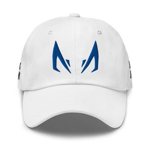 Könnte beinhalten: Eine weiße Baseballkappe mit einer blauen Stickerei auf der Vorderseite, die zwei stilisierte, spitze Formen darstellt. An den Seiten der Kappe ist teilweise schwarzer Text zu sehen, und sie verfügt über einen gebogenen Schirm und Ösen.