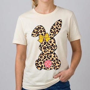 Könnte beinhalten: Ein Set aus drei Keramikbechern mit gesprenkelter, matter Oberfläche. Die Becher sind in Creme-, Hellgrau- und Dunkelgrautönen gehalten. Jeder Becher hat ein schlichtes, minimalistisches Design.