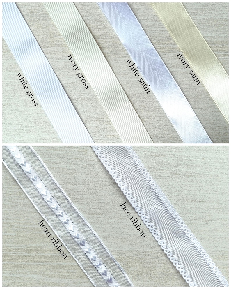 May include: Assortment of ribbons in various shades of white and ivory. The ribbons include white gross, ivory gross, white satin, ivory satin, heart ribbon, and lace ribbon. The ribbons are displayed diagonally against a light wood grain background.