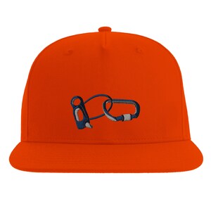 Peut inclure: Casquette orange à visière plate ornée d'une broderie d'équipement d'escalade, comprenant un descendeur et un mousqueton. Le motif est bleu et blanc. La casquette a une coupe structurée et une visière plate.