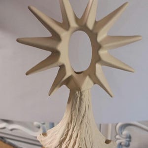 Peut inclure: Ensemble de trois mugs en céramique avec une finition mate et mouchetée. Les mugs sont de couleur crème, gris clair et gris foncé. Chaque mug a un design simple et minimaliste et une anse arrondie. Les mugs sont empilés.