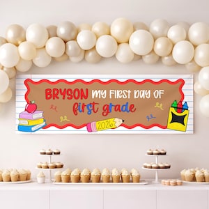 Könnte beinhalten: Ein rechteckiges Banner mit einer beigen Mitte und roten Wellenrändern auf weißem linierten Papierhintergrund. Der Text lautet: BRYSON MY FIRST DAY OF first grade 2026. Illustrationen zeigen einen Bücherstapel mit Apfel, einen Stift und Buntstifte.