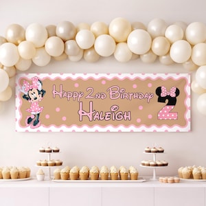 Puede incluir: Una pancarta de cumplea&ntilde;os con el texto "Happy 2nd Birthday Haleigh" en rosa, con Minnie Mouse y el n&uacute;mero 2 con lunares. La pancarta es marr&oacute;n con un borde rosa y lunares, con globos y cupcakes en el fondo.