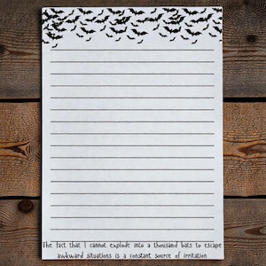 May include: White lined notepad with a black bat silhouette border. The notepad has a humorous quote at the bottom: "The fact that I cannot explode into a thousand bats to escape awkward situations is a constant source of irritation."