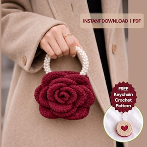 May include: A burgundy crochet bag shaped like a rose, held by a handle adorned with white pearls. The bag is held in front of a tan coat. Text on the image reads "INSTANT DOWNLOAD | PDF" and "FREE Keychain Crochet Pattern."