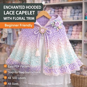 Puede incluir: Un capulet de encaje de ganchillo con capucha, adornado con flores, un broche y borlas. El texto de la imagen dice "ENCHANTED HOODED LACE CAPELET WITH FLORAL TRIM" y "Beginner Friendly". El patrón es fácil de seguir.