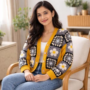 K&ouml;nnte beinhalten: Ein geh&auml;kelter Cardigan in Gelb, Grau und Wei&szlig; mit einem floralen Muster. Der Cardigan hat eine Knopfleiste vorne und wird &uuml;ber einem wei&szlig;en Oberteil getragen. Die &Auml;rmel und der Besatz sind gelb, und der K&ouml;rper hat quadratische H&auml;kelbl&ouml;cke mit Blumenmustern.