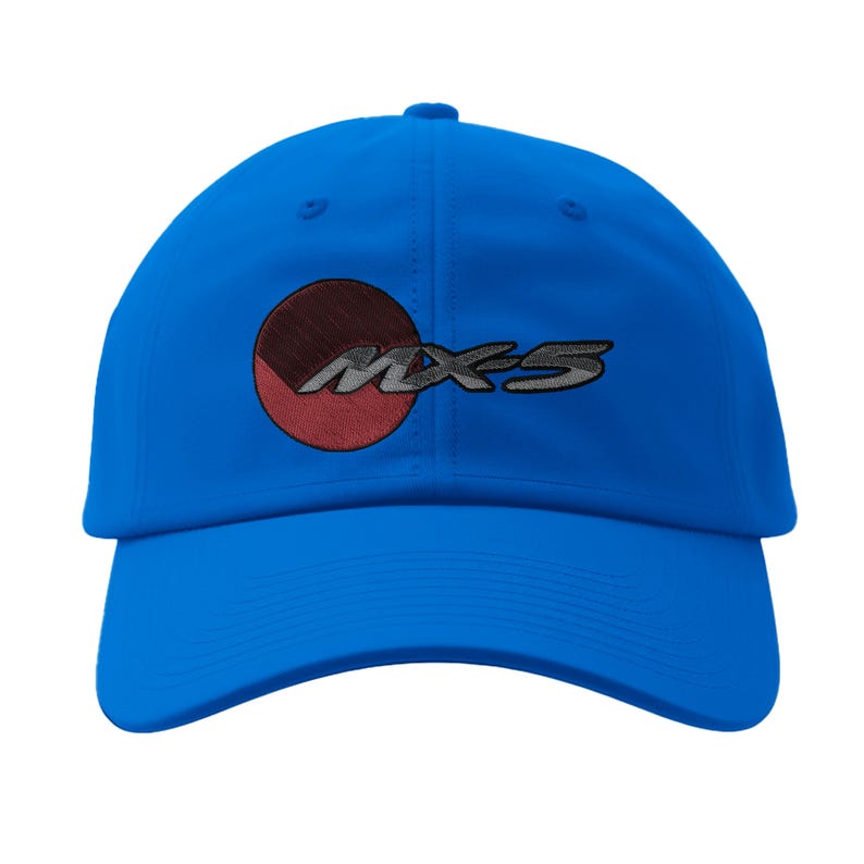 May include: A bright blue baseball cap with the embroidered text "MX-5". The logo features a red and brown circle with a silver outline. The cap has a curved brim and a fabric strap closure.