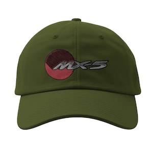 May include: Olive green baseball cap featuring the embroidered text "MX-5" in silver, with a red and maroon circular design. The cap has a curved brim and a structured crown, suitable for casual wear.