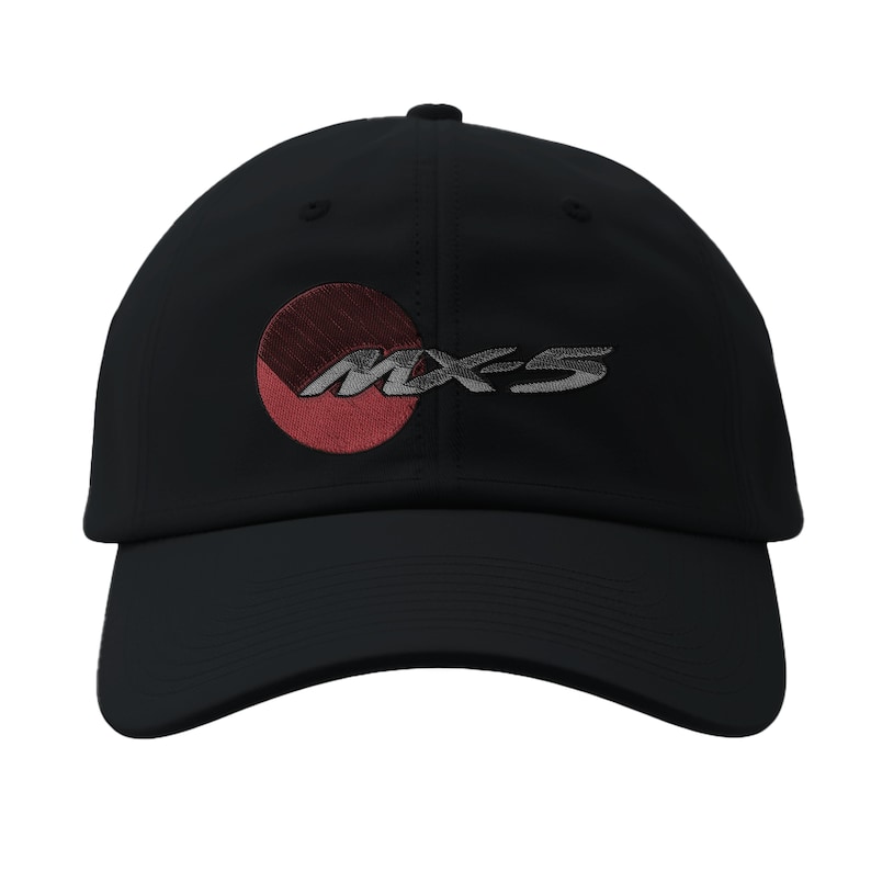 May include: Black baseball cap featuring the embroidered text "MX-5" in silver, with a red and maroon circular design. The cap has a curved brim and a structured crown, suitable for sun protection.