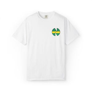 Könnte beinhalten: Weißes T-Shirt mit einem kleinen, kreisförmigen Design auf der linken Brust. Das Design hat eine grüne und gelbe Farbgebung mit einer stilisierten Form. Das Shirt hat einen Rundhalsausschnitt und kurze Ärmel.