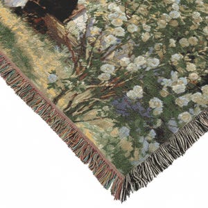 Pode incluir: Cobertor tecido com uma cena pastoral com flores brancas, folhagem verde e uma &aacute;rvore. O cobertor tem uma borda com franjas com uma mistura de cores. O canto do cobertor &eacute; vis&iacute;vel, mostrando o design detalhado.