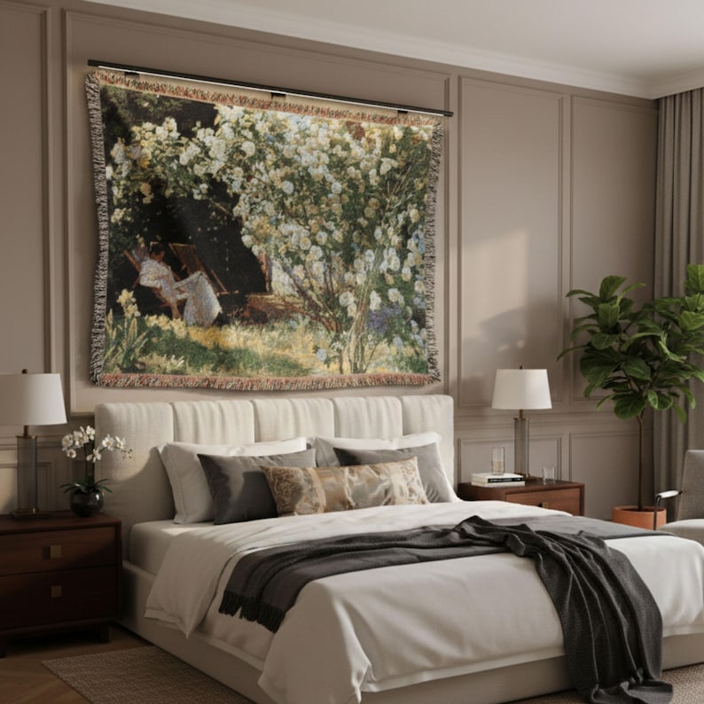Pode incluir: Uma tape&ccedil;aria tecida retratando uma cena pastoral com figuras sob uma &aacute;rvore florida. A obra de arte apresenta uma paleta de verdes, brancos e castanhos, com uma barra preta para pendurar. A tape&ccedil;aria &eacute; exibida acima de uma cama com um esquema de cores neutras.