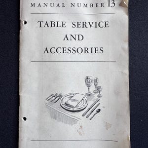 Puede incluir: Manual vintage titulado "Table Service and Accessories" con ilustración de una mesa puesta. El manual es de color blanquecino con texto negro y una ilustración en blanco y negro de un plato, cubiertos y cristalería.