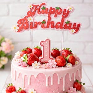 Puede incluir: Una tarta rosa con goteo de glaseado blanco, cubierta con fresas frescas, flores y un adorno de tarta de "Feliz Cumpleaños". Una vela rosa con el número uno. Decoración para un primer cumpleaños.