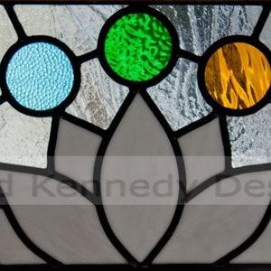 May include: A stained glass window with a lotus flower design. The flower has seven petals and is surrounded by eight round, colored glass pieces. The colors are purple, blue, light blue, green, yellow, red, and orange.