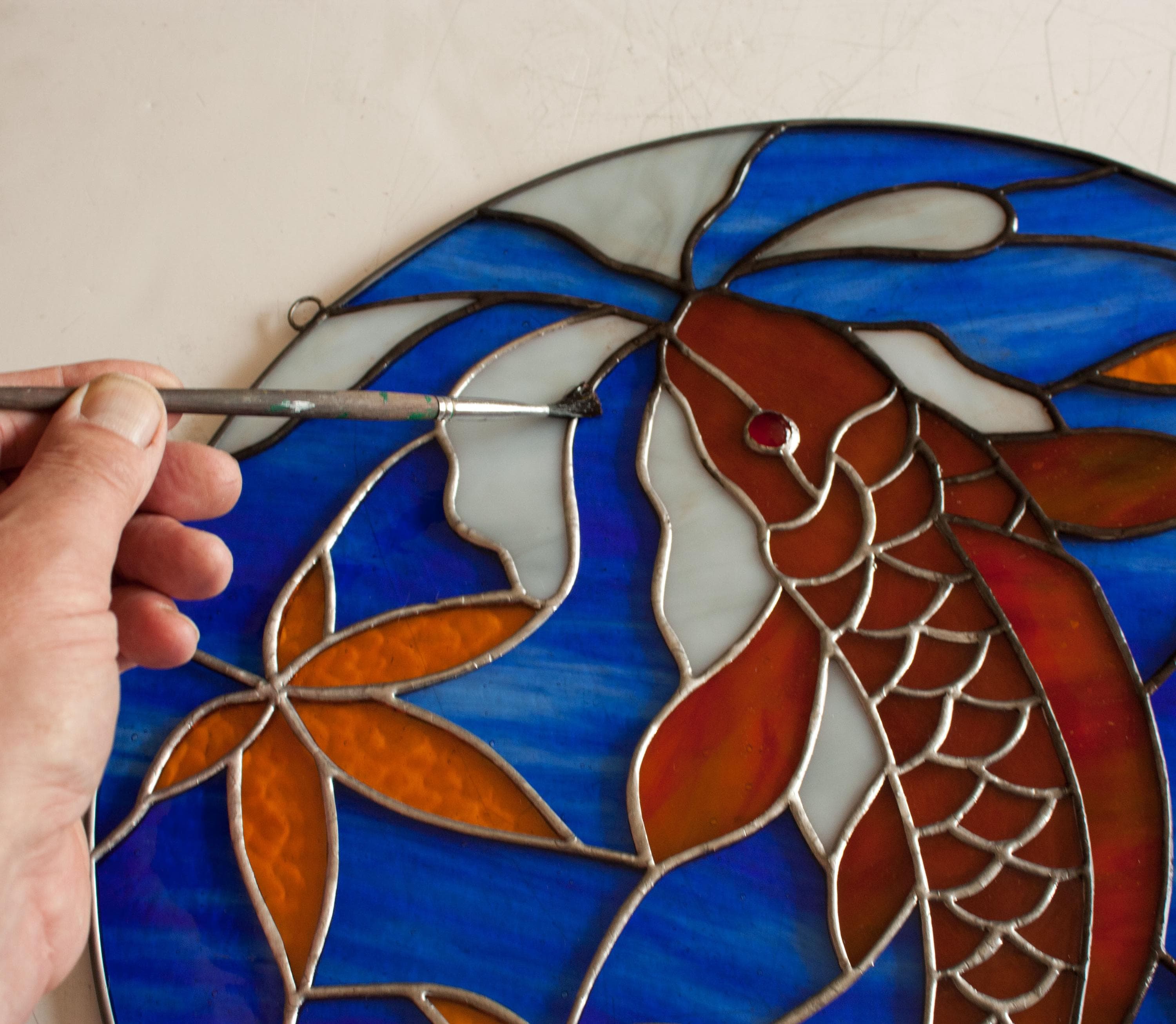 鯉とカエデの葉のステンドグラスの模様。© David Kennedy Designs