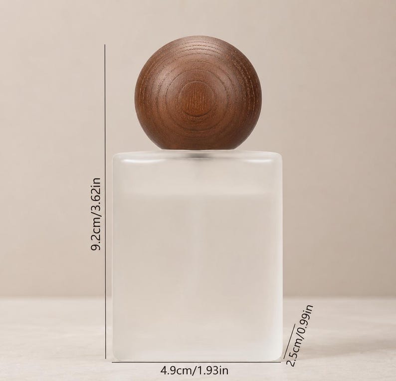 May include: A rectangular frosted glass perfume bottle with a round dark brown wooden cap. The bottle measures 3.62 inches in height, 1.93 inches in width, and 0.99 inches in depth, as indicated by the visible measurement lines and text.