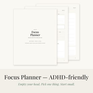Könnte beinhalten: Ein weißer Focus Planner mit schwarzem Text, der Focus Planner, Empty your head. Pick one thing. Start small. lautet. Der Planer wird mit mehreren gestapelten Seiten gezeigt, die interne Abschnitte mit linierten Bereichen für Notizen offenbaren.