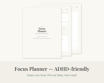 May include: A white Focus Planner with black text that reads Focus Planner, Empty your head. Pick one thing. Start small. The planner is shown with multiple pages stacked, revealing internal sections with lined spaces for notes and task tracking.