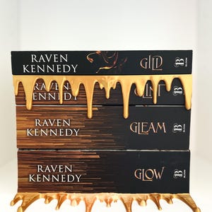 May include: A stack of three books with black covers and gold lettering, titled "Gild", "Gleam", and "Glow" by Raven Kennedy. The books are adorned with a gold, dripping design, and the Bloom logo.