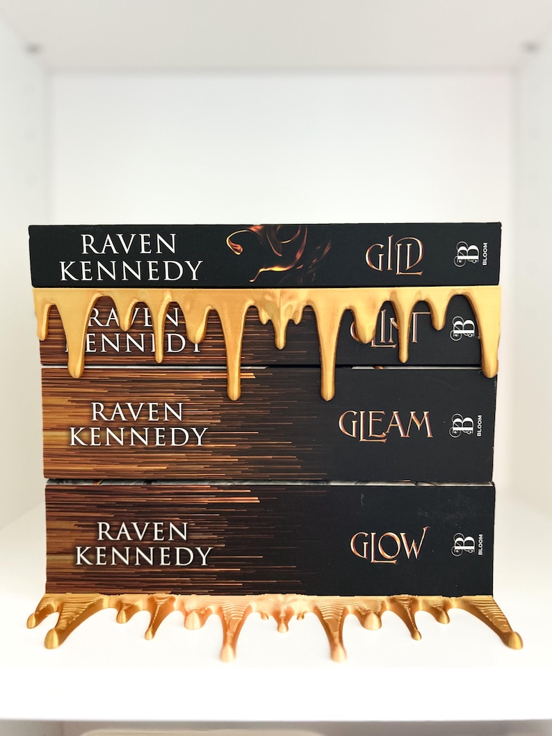 May include: A stack of three books with black covers and gold lettering, titled "Gild", "Gleam", and "Glow" by Raven Kennedy. The books are adorned with a gold, dripping design, and the Bloom logo.