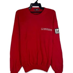 May include: A red long-sleeve sweatshirt with the Honda logo on the chest and sleeve. The Honda logo is white and the sleeve logo is in a white square. The sweatshirt is hanging on a black hanger.