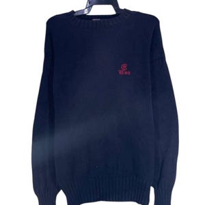 May include: Navy blue sweater with a crew neck and long sleeves. The sweater features a red logo with the text "RL-83" on the chest. The sweater is hanging on a black hanger against a white background.