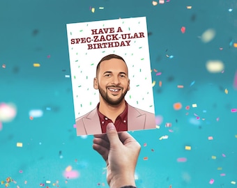 May include: A rectangular greeting card with a white background featuring a cartoon illustration of a smiling man with a beard wearing a maroon shirt and a light pink blazer. The text "HAVE A SPEC-ZACK-ULAR BIRTHDAY" is printed in maroon.