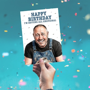 May include: A white rectangular birthday greeting card featuring a cartoon illustration of a smiling person wearing a black t-shirt and blue denim overalls, holding a ceramic mug. The text reads HAPPY BIRTHDAY I'M GETTING ALL EMOTIONAL.