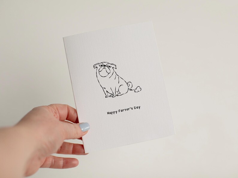 May include: A white greeting card featuring a black line drawing of a pug dog with a small cloud behind it. Below the illustration, the text reads "Happy Farter's Day" in a simple black font. The card has a textured surface and a folded edge.
