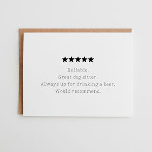 May include: A white greeting card with a brown envelope. The card features five black stars above the text: "Reliable. Great dog sitter. Always up for drinking a beer. Would recommend."