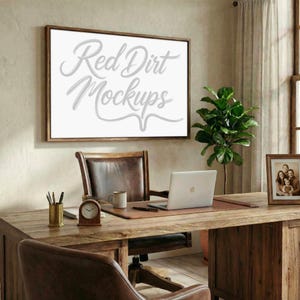 May include: A wooden desk with a laptop, clock, and pen holder. A framed sign with the text "Red Dirt Mockups" hangs on the wall above the desk. A leather chair and a framed family photo are also visible.