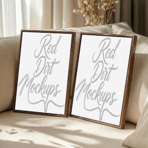 Könnte beinhalten: Zwei gerahmte Kunst-Mockups mit weißen Hintergründen und dem Text "Red Dirt Mockups" in einer Schreibschrift. Die Rahmen sind dunkelbraun. Die Mockups werden auf einem beigen Sofa präsentiert.