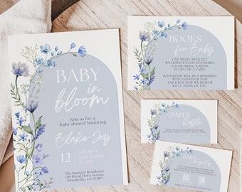 Op de afbeelding: Blauwe en witte babyborrel uitnodigingskaarten met bloemmotieven. De hoofkaart zegt "Baby in Bloom" en bevat de naam "Blake Joy". De andere kaarten zeggen "Books for Baby" en "Diaper Raffle".